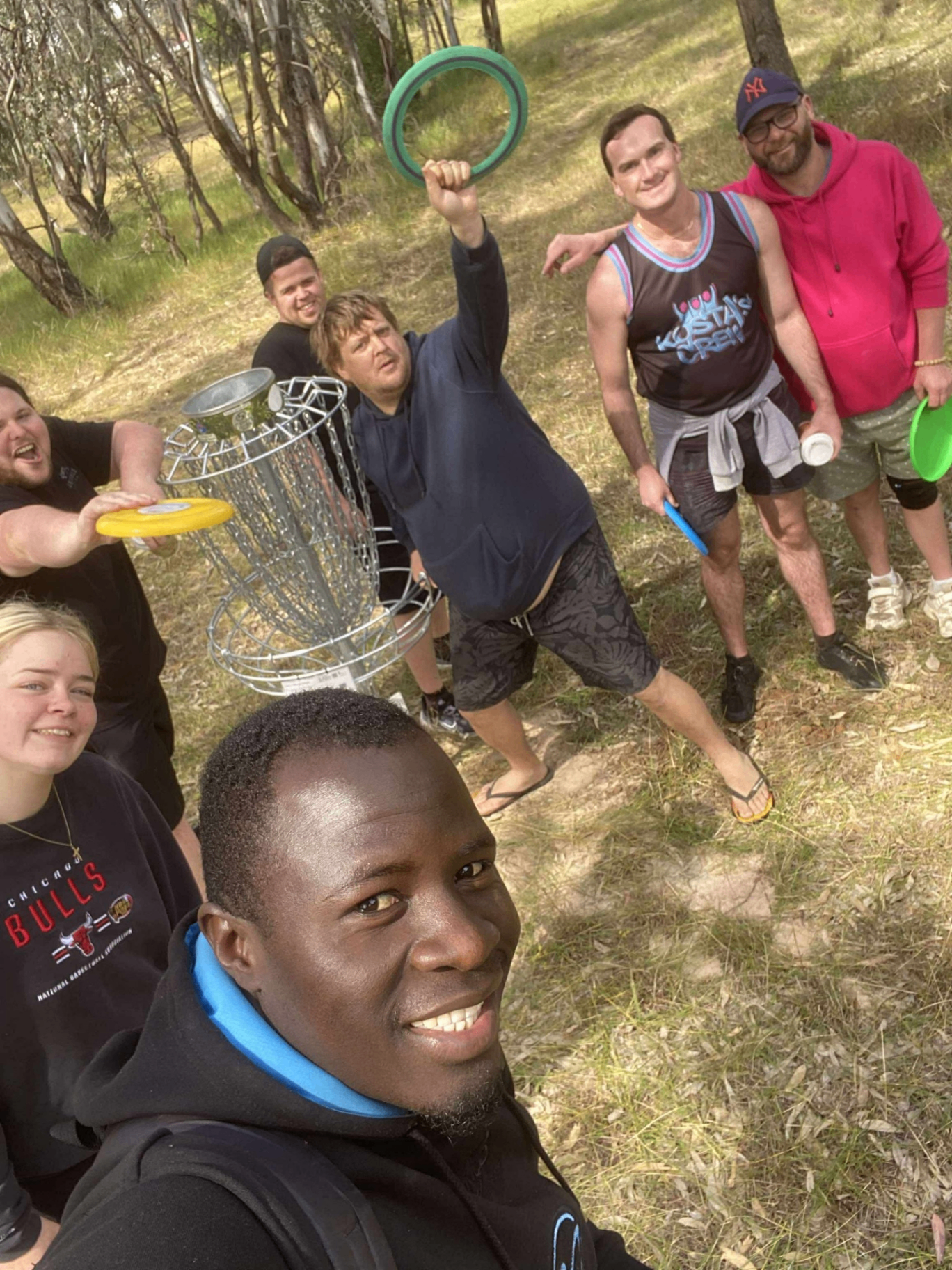 Crew members playing disc golf in the bush
